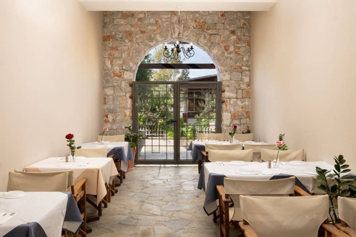 mese asezate intr-o curte interioara cu o poarta boltita,intr-un zid de piatra