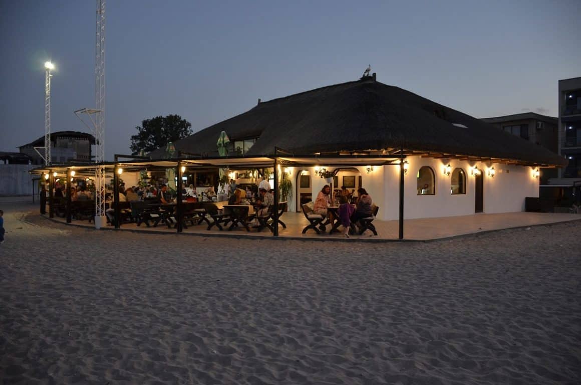 Oameni care iau masa seara pe terasa la La Stuf, cherhanale de pe litoralul românesc