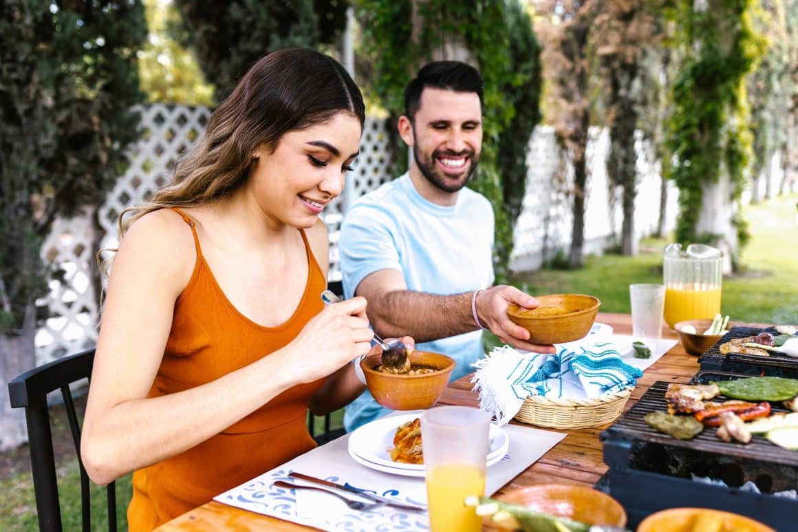 cuplu ia masa vara, in gradina. Imagine reprezentativa pentru mancare sanatoasa si alimente care favorizează inflamația în organism
