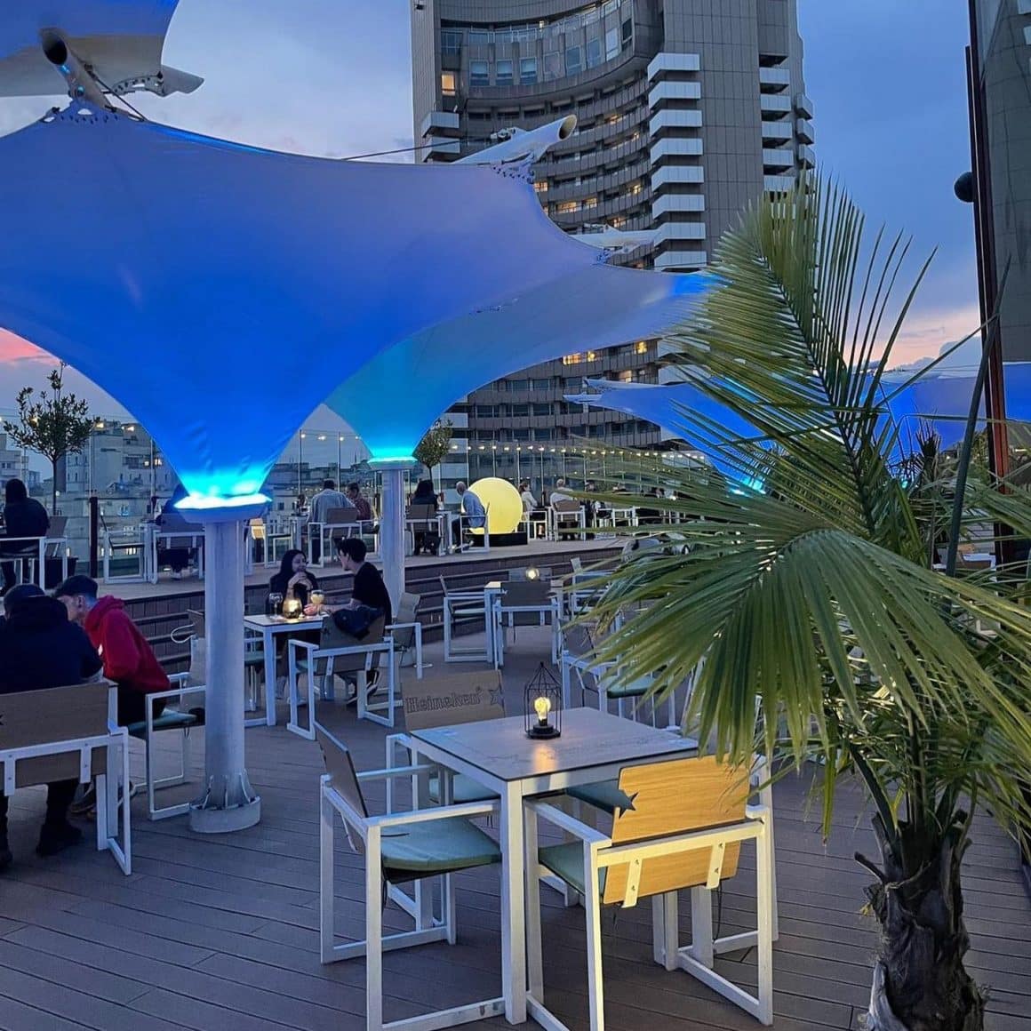 terasa de la Aria TNB București, fotografiata seara, cu luminile aprinse pe tarasa si oameni la masa