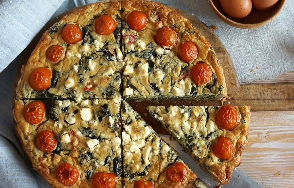 Quiche cu branza, spanac si rosii din care este taiata o felie, de la Chez Odette București