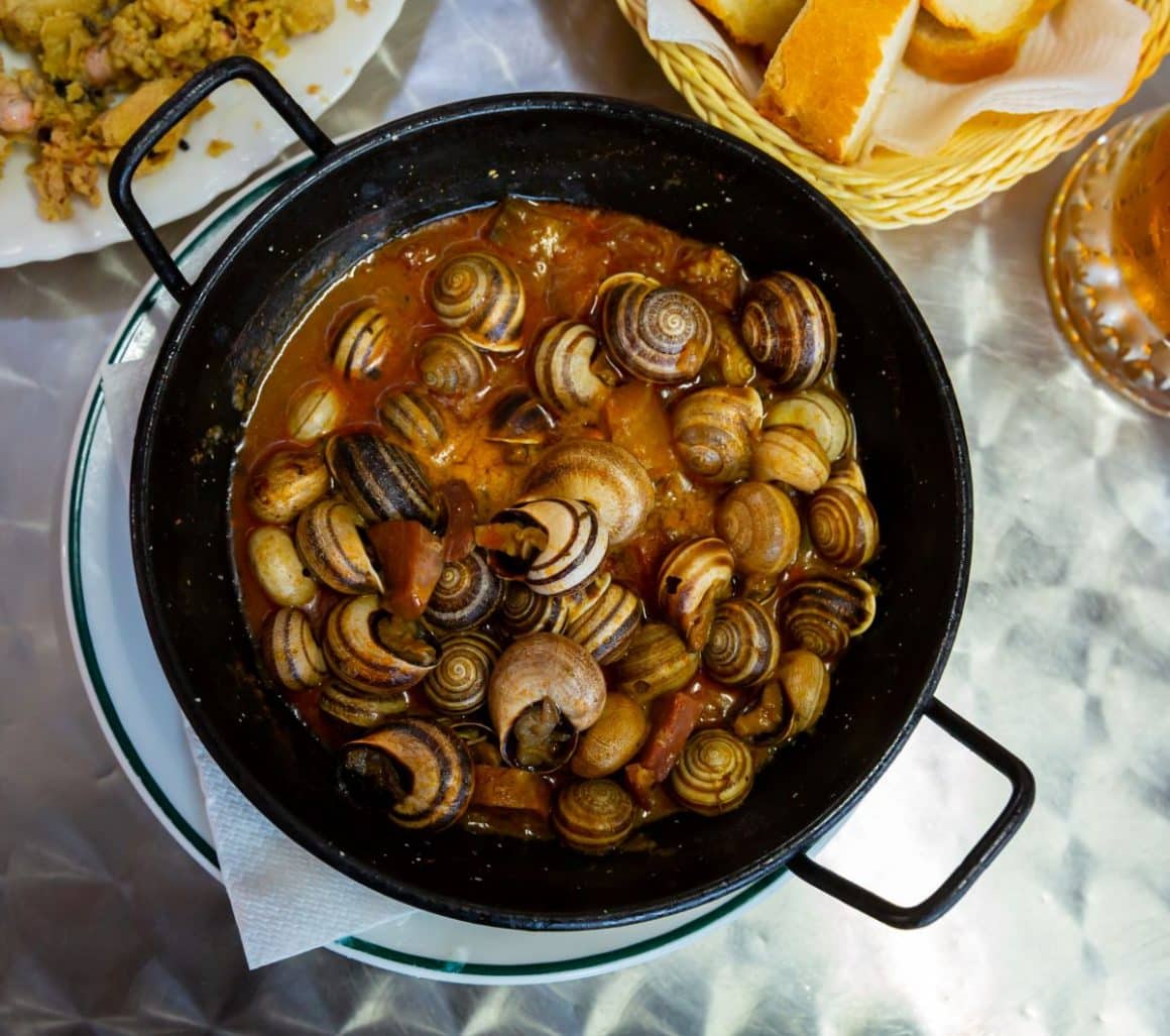 o portie de melci este servita intr-o tigaie alaturi de alte preparate. Preparate tradiționale din Sardinia