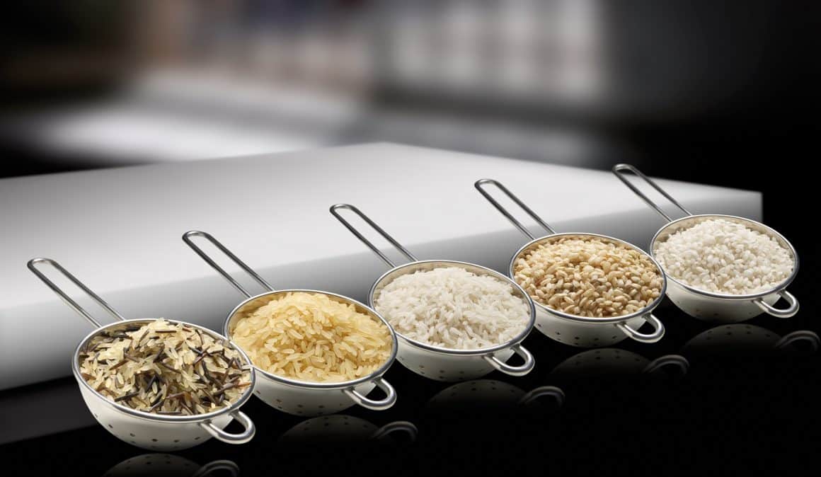 Mai multe tipuri de orez, fiecare asezat in cate o strecurătoare, pe fundal negru