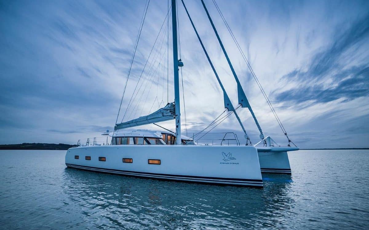 un catamaran cu panzele stranse pluteste pe marea calma