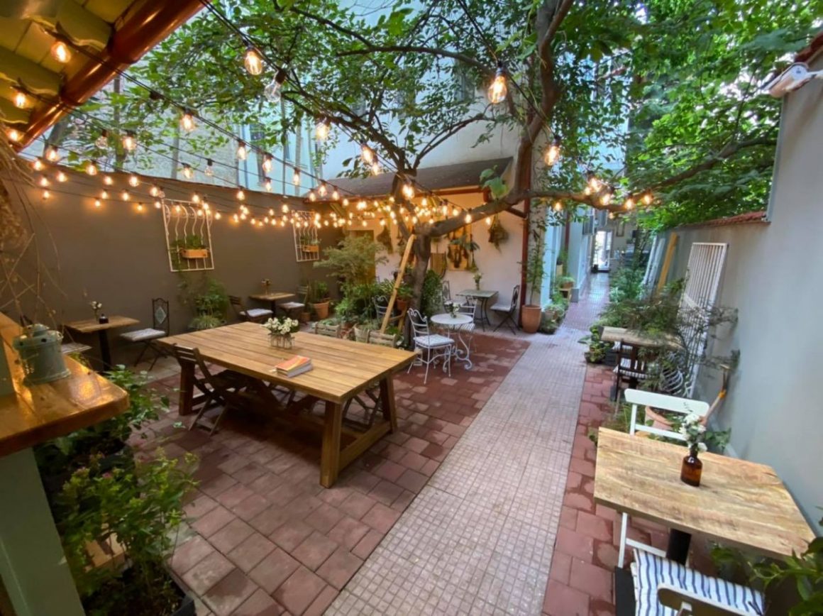 terasa gradinii bacania veche cu multe flori si ghirlande luminoase