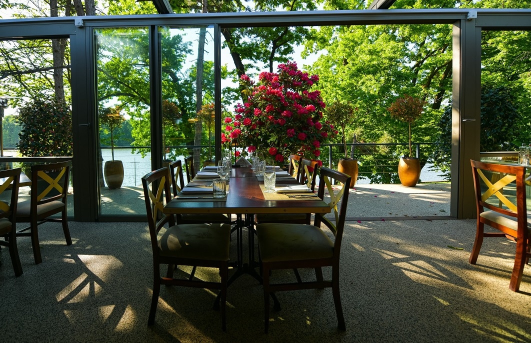 mese in restaurant Zexe, asezate in fata unui geam mare, cu vedere spre lac