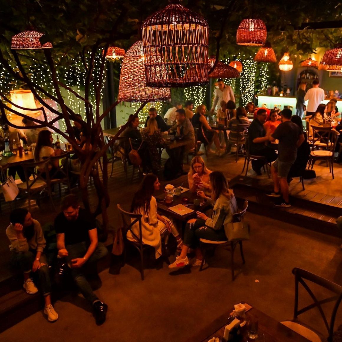 terasa de la gspot sufrageria, plina de lcienti seara, iluminata discret. Grădini din București