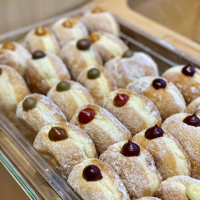 mai mult eranduri cu gogosi umplute cu diverse arome la berliner donuts. Deserturi cu ciocolată București