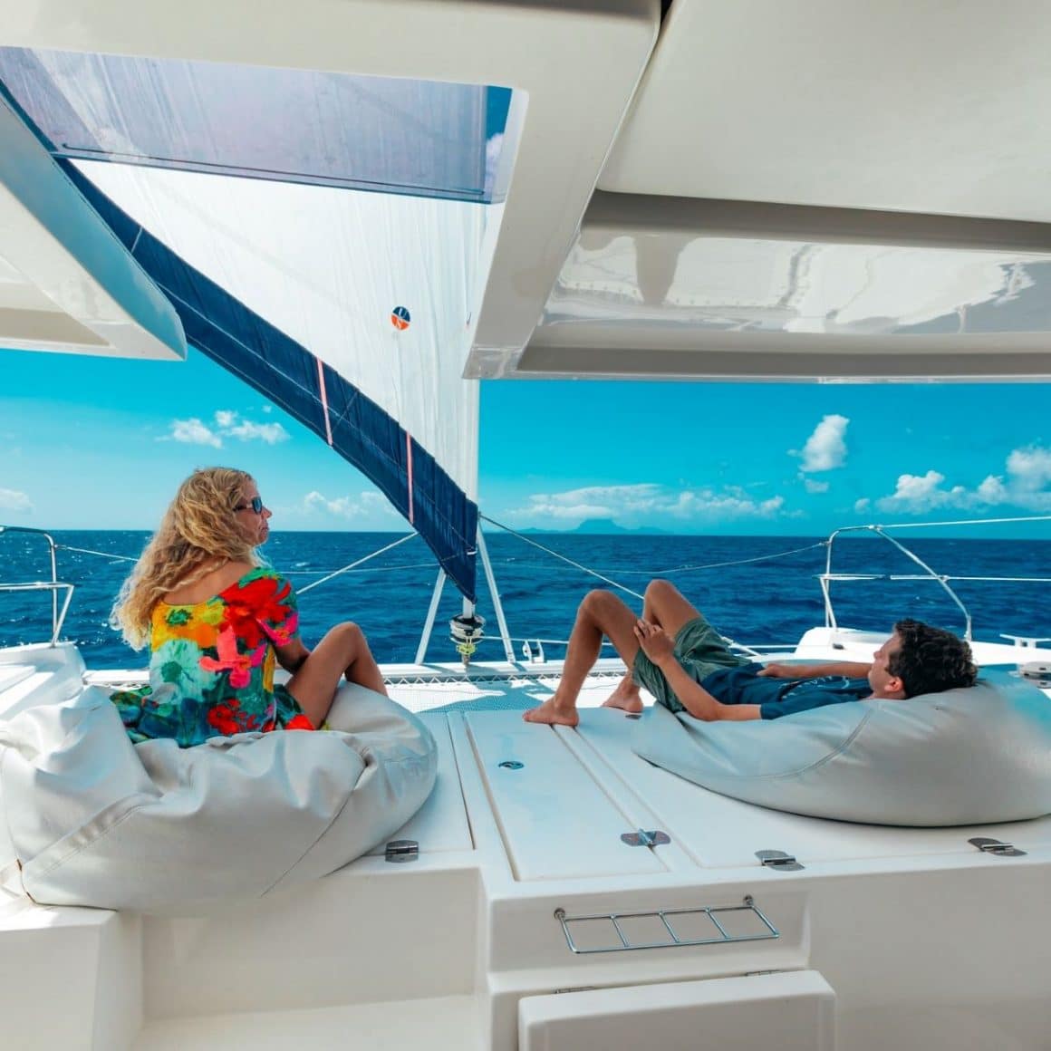 un cuplu se relaxează pe pernele de pe puntea unui iaht