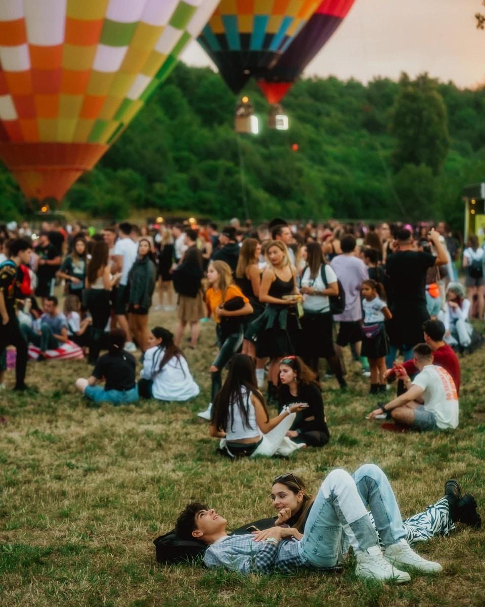 Oameni se relaxează pe iarbă la Electric Castle 2023. 