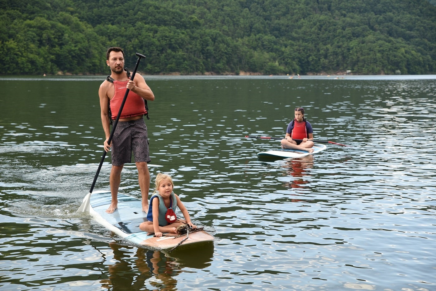 un tata si fetita lui pe un paddle, pe lacul Tarnița din CLuj. Destinații de vară pentru familiile cu copii