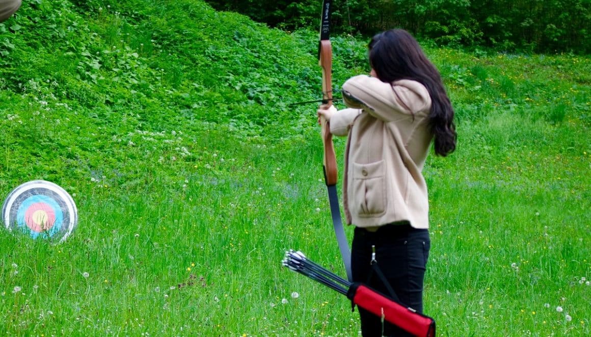 o femeie trage cu arcul la tinta la parcul de aventură de la Castelul Cantacuzino. 