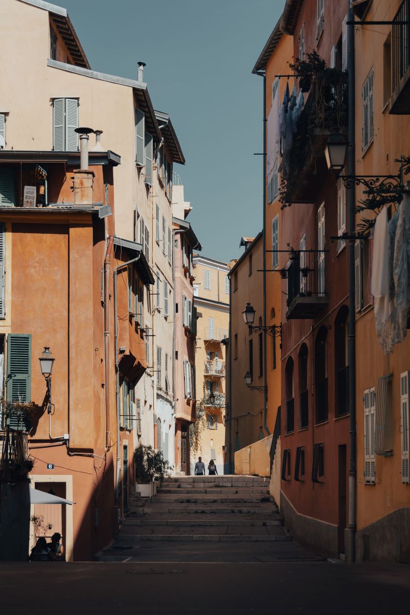 o straduta ingusta cu clădiri bej și albe și scări late, tipic orasului nisa