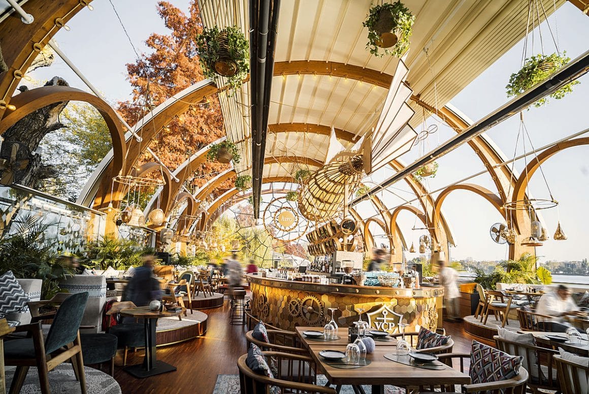 Arcade înalte din lemn, îmbinate cu motivele vizuale incașe alcatuiesc decorul boho chic al restaurantului hiro bay