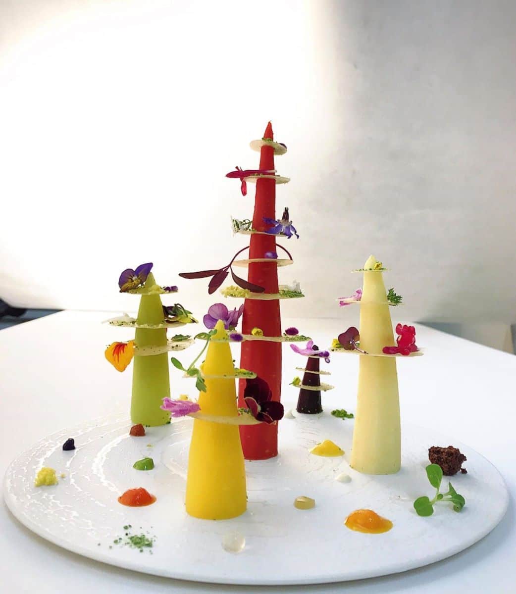 mai multe turnulețe comestibile de diferite culori sunt asezate pe o farfurie alba