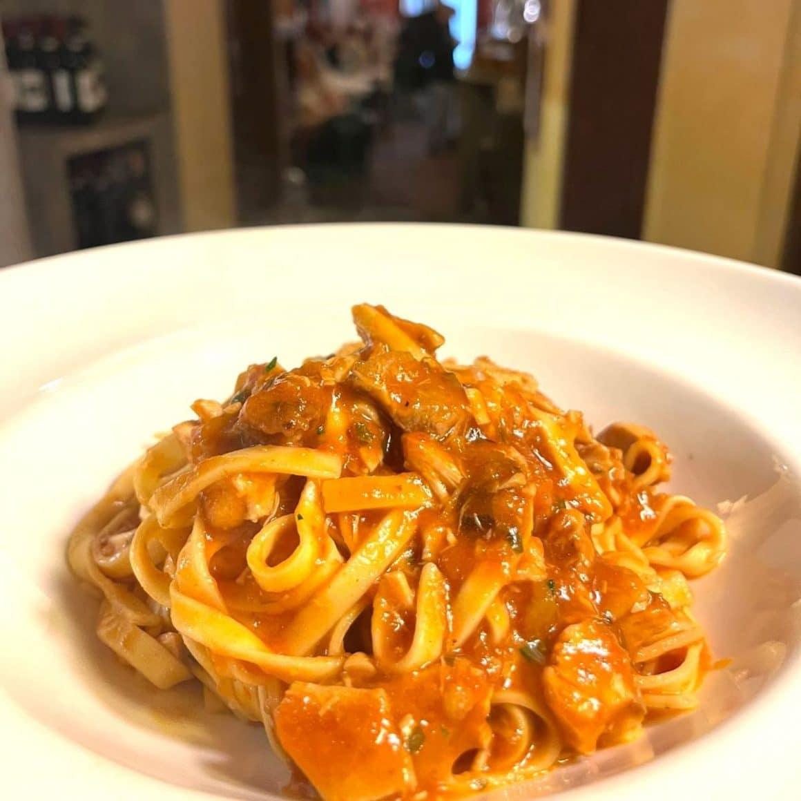 o portie de paste pici, una dintre mancarurile traditionale din toscana, intr-o farfurie alba de paste