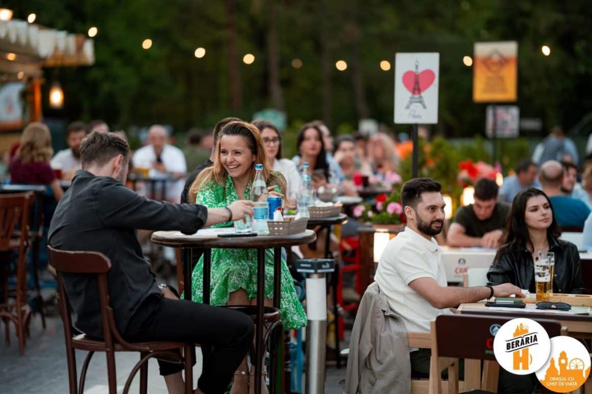 mai multi tineri stau pe scaune la una dintre mesele restaurantului Berăria H, unul din locurile cu muzică live din bucuresti