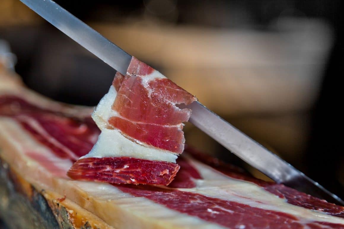 un cutit foarte lung feliaza un picior de porc obtinand o felie de jamon serrano