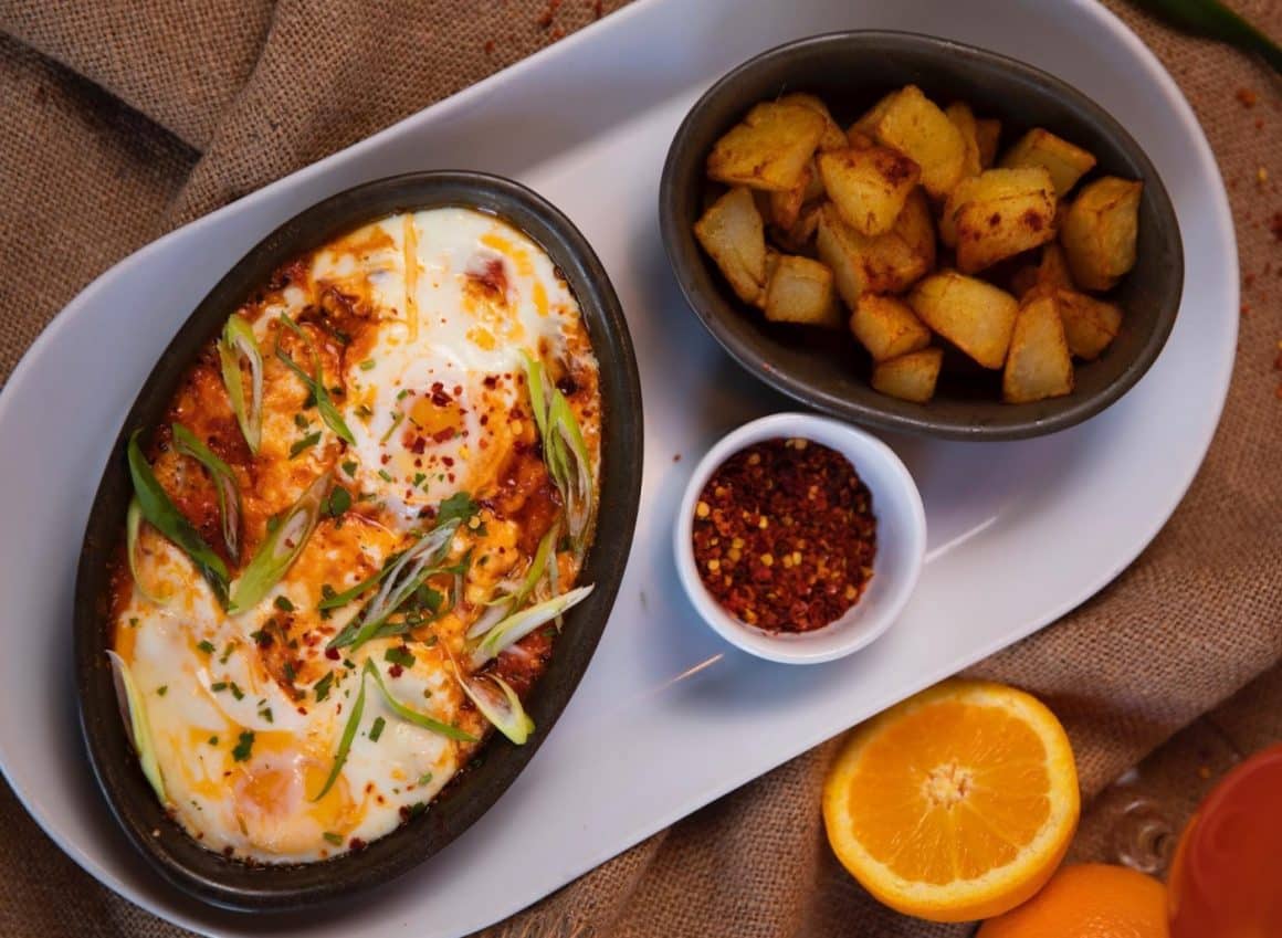 shakshuka cu ouă, cartofi prăjiți, sos de roșii, brânză de vacă, ardei gras, usturoi și ceapă verde.