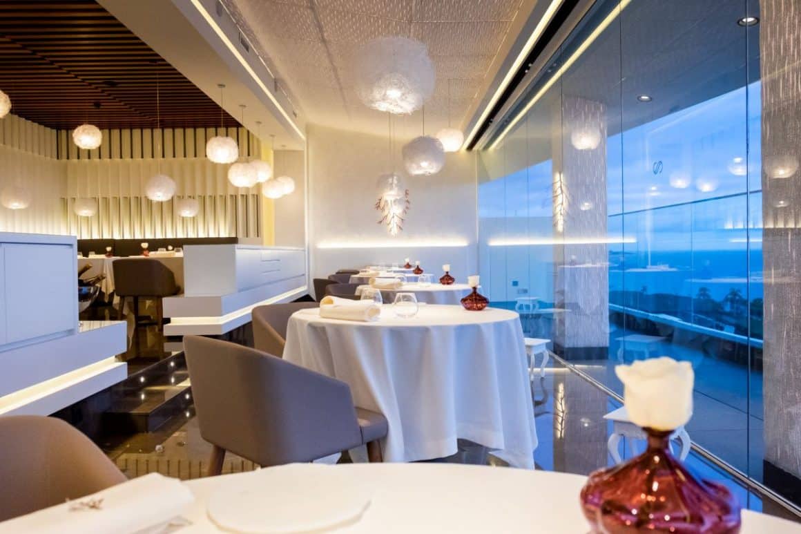 interiorul restaurantului El Rincon de Juan Carlos. din tenerife, cu mese și scaune asezate in fata unui perete de sticla