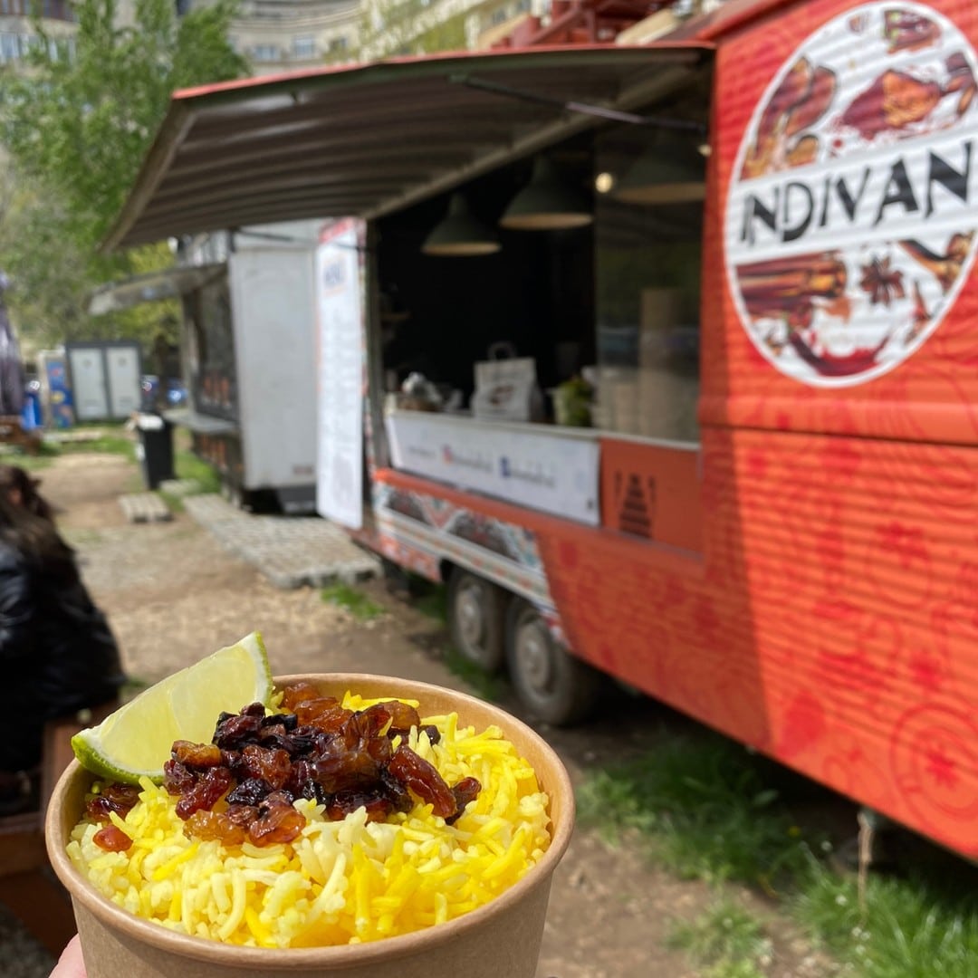 close up cu un preparat de street food iar in fundal camioneta Indivan. Street food București