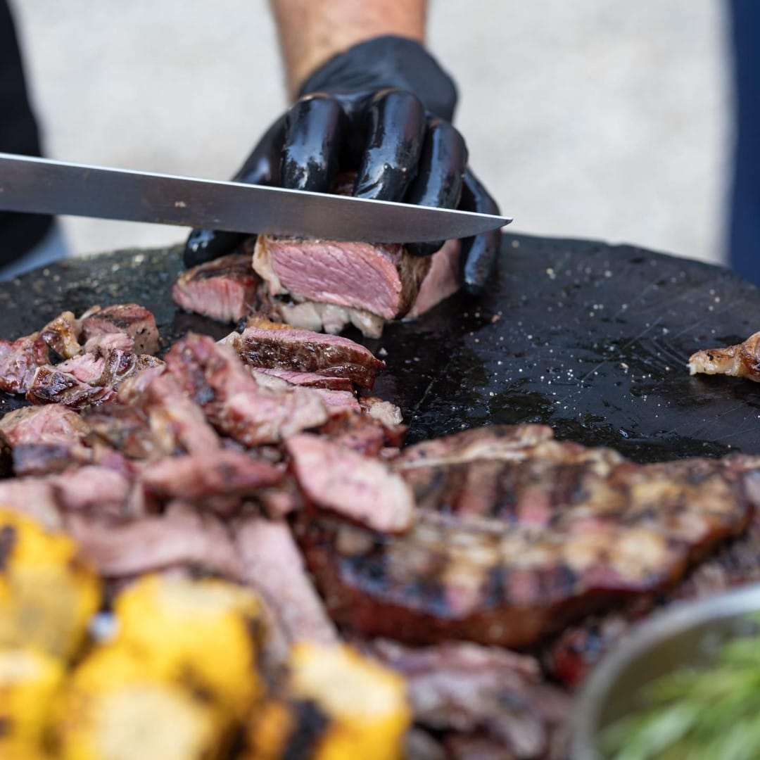 steak de vita din care cineva taie cu cutitul, de la Smokareala din cadrul Kraft Market. Street food în București