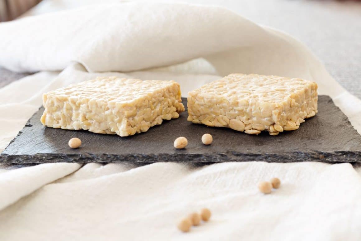 doua felii de tempeh, o sursa de proteine vegetale, sunt asezate pe un blat negru de marmura