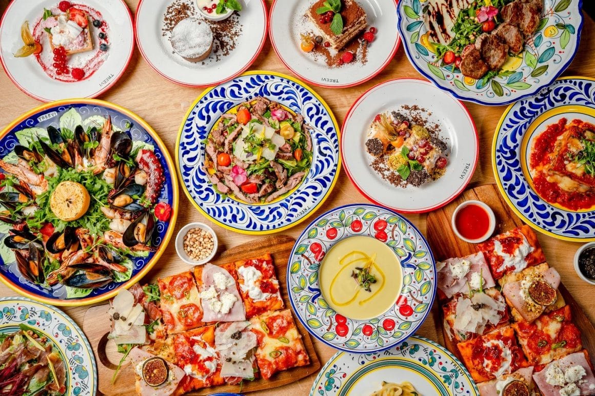 mai multe ferfurii pictate rustic, in stil mediteranean, cu diverse preparate specifice bucatariei italiene