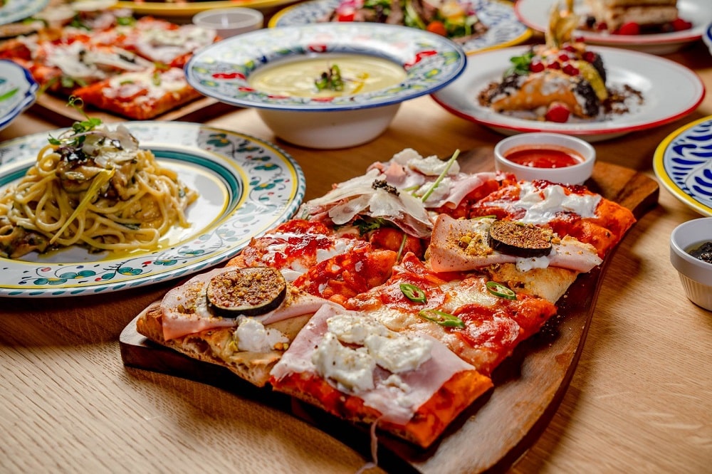 felie mare de pizza servita pe blat de lemn laTreevi Pizza & Gin Bar