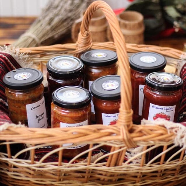 mai multe borcane cu zacusca de la producători locali sunt asezate intr-un cos de răchită