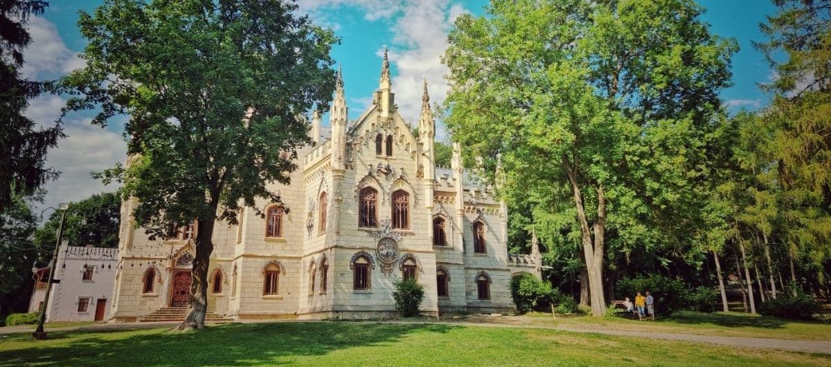 intrarea intr-un conac impunător, incadrata de doi copaci