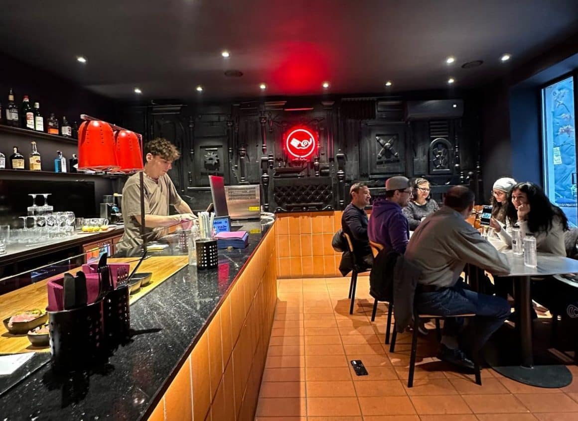 Interiorul restaurantului Smokareala, cu oameni care iau masa si in fundal cuptoarele mari. Steakhouse din București