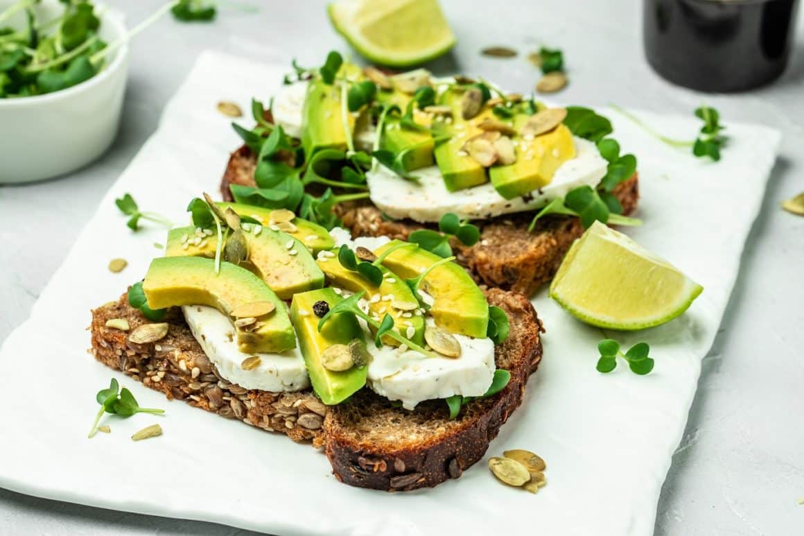 Avocado toast cu brânză și lime, pe pâine neagră cu semințe