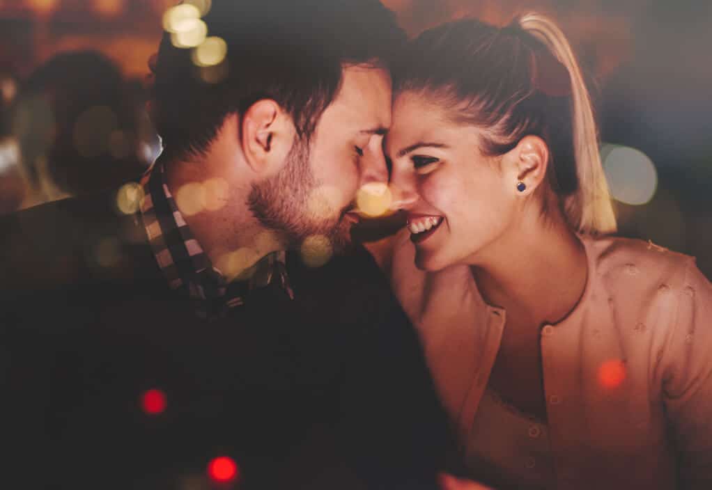 doi iubiți tineri își apropie corpurile zâmbind