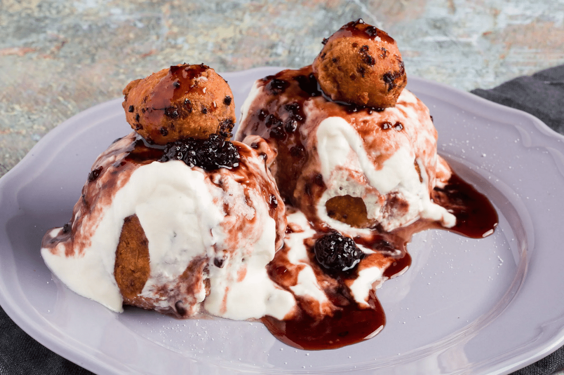 close up cu 2 papanasi cu dulceata de afine si smantana, in prim plan, la restaurant La Mama București