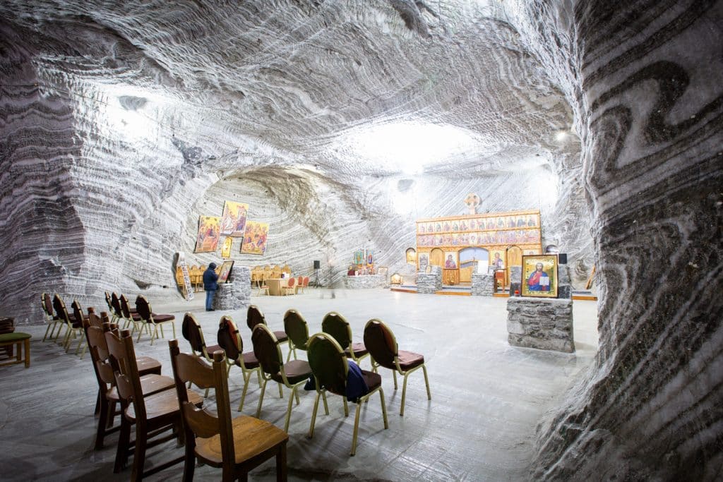 o mică capelă ortodoxă cu câteva rânduri de scaune și un altar aflat la interiorul uneia dintre salinele din românia