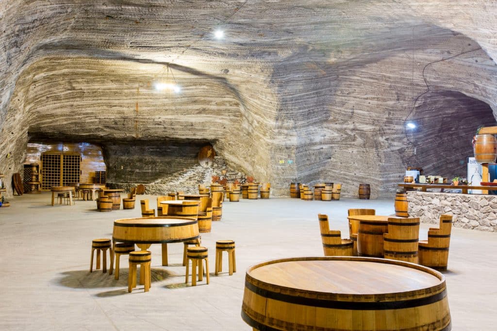 mese din lemn ca niste butoaie si scaunele de lemn, in salina Ocnele Mari, una din salinele din România