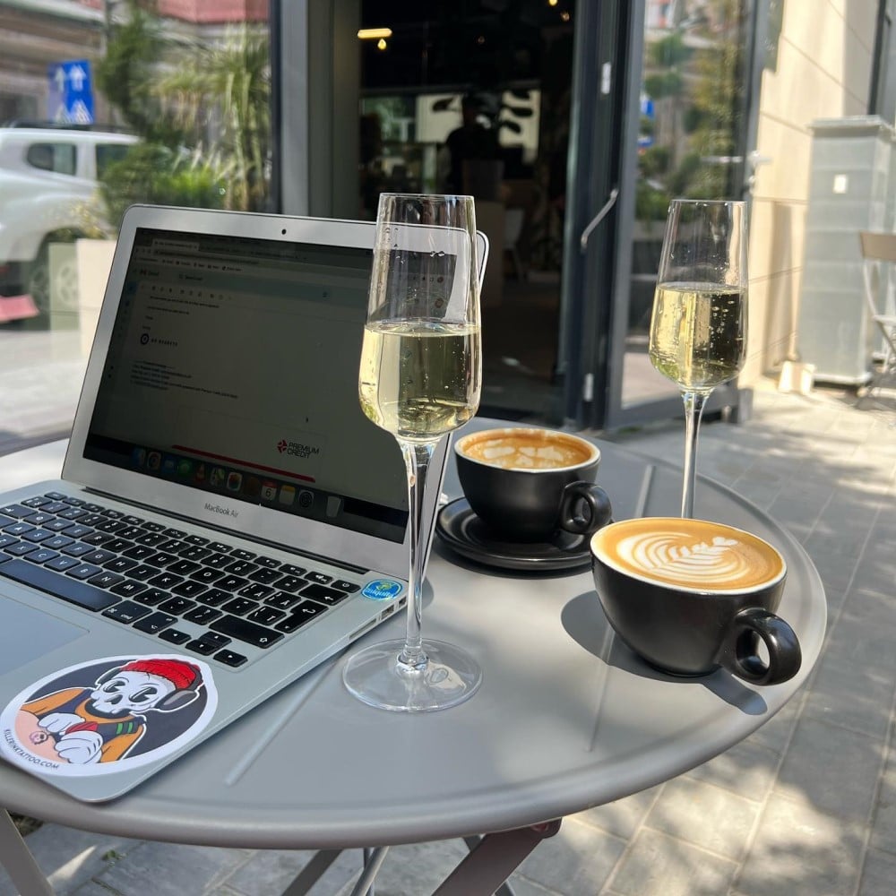 laptop alaturi de 2 cesti de cafea si 2 pahare de prosecco la Teto, una din cafenele moderne unde poți lucra