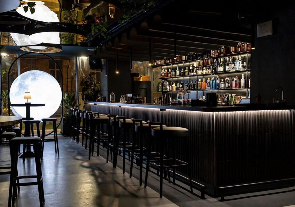 Imagine din barul The Owl Bucuresti decoart in negru, si cu un corp de iluminat asemanator cu o luna. restaurante 1 Martie