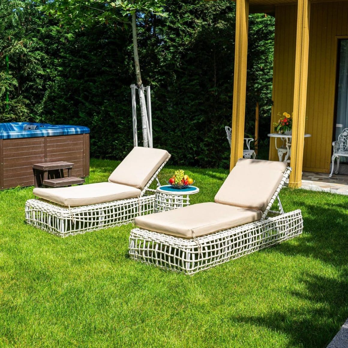 două chez longuri albe sunt puse pe peluza cu gazon a unui spa din românia