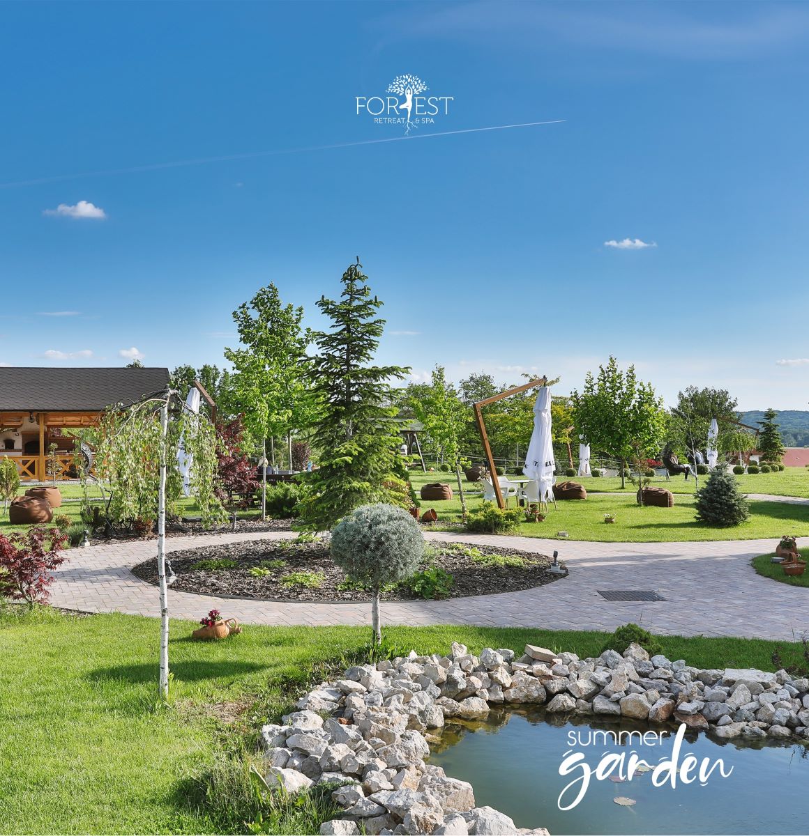 grădina ingrijita, cu un iaz pietruit și alei de plimbare a unei locații spa din România. Forest Retreat