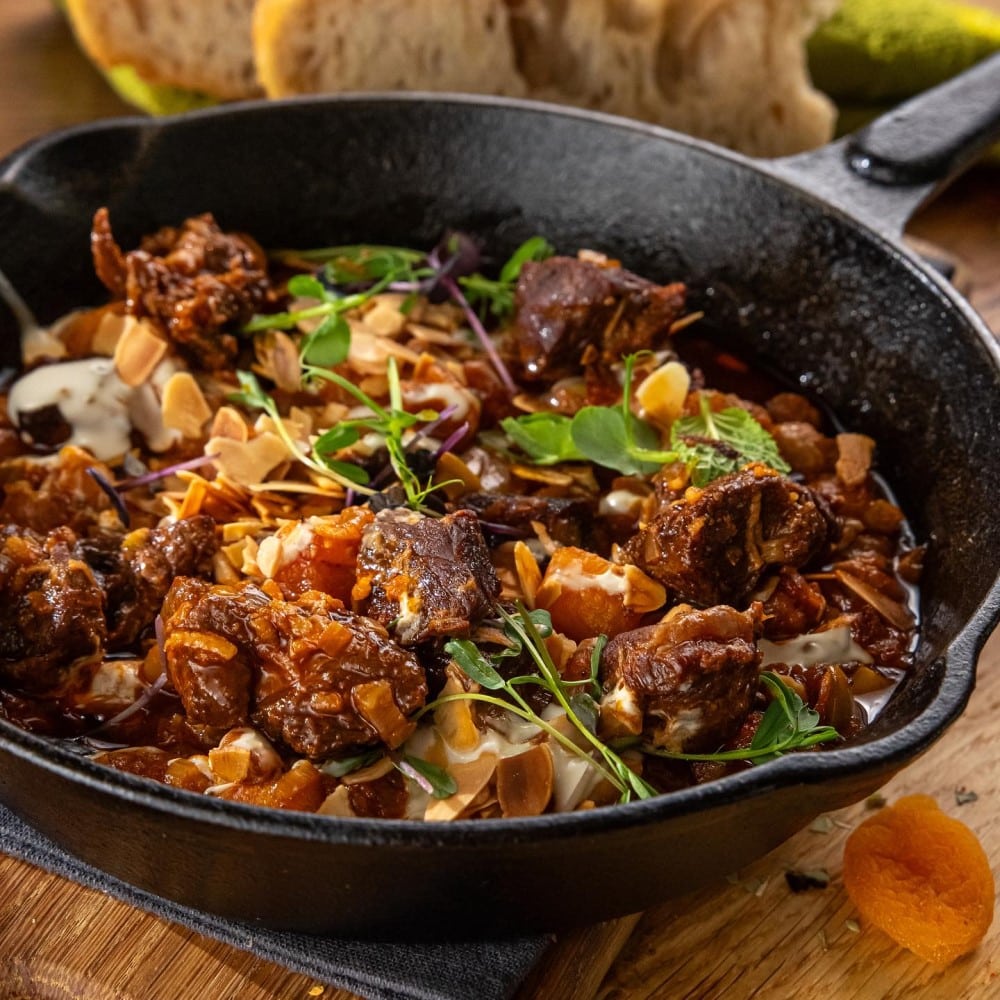 miel marocan, amestecat cu caise uscate, măsline verzi, vin alb și dressing de tahini, acoperit cu migdale prăjite și coriandru