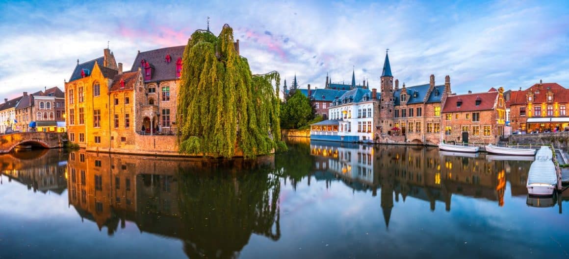 mai multe case foarte veci sunt asezate printre canalele din bruges, la apus