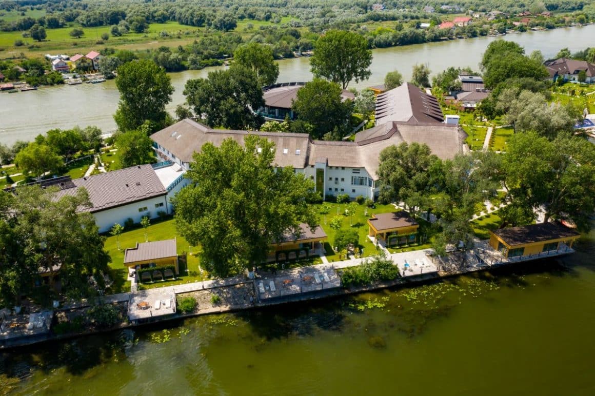 complexul spa lebada luxury resort and spa din delta dunării, marginit de ape pe ambele laturi ale propietății. Locații spa din România