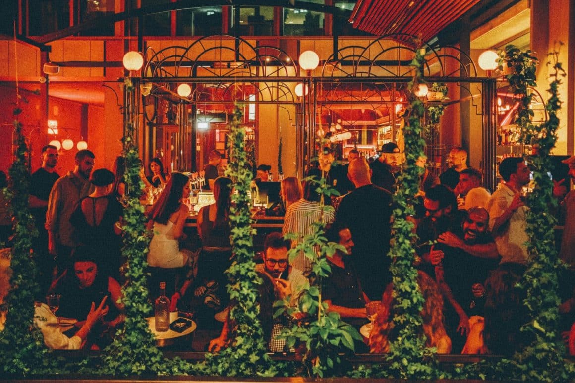 oameni asezati seara la mese in curtea de la Negroni Aperitivo Bar București