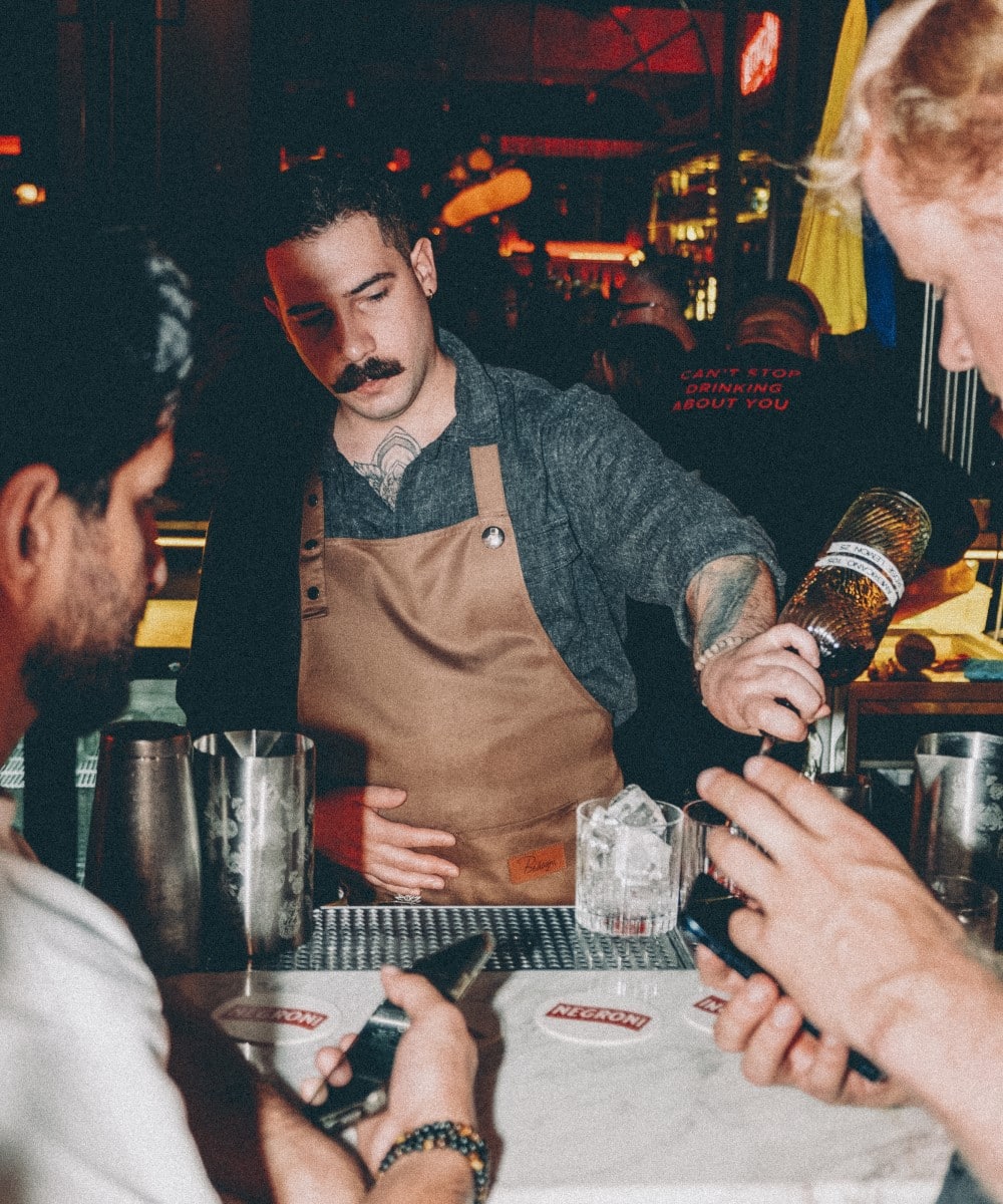 barman toarna bautura in paharele a doi oaspetu