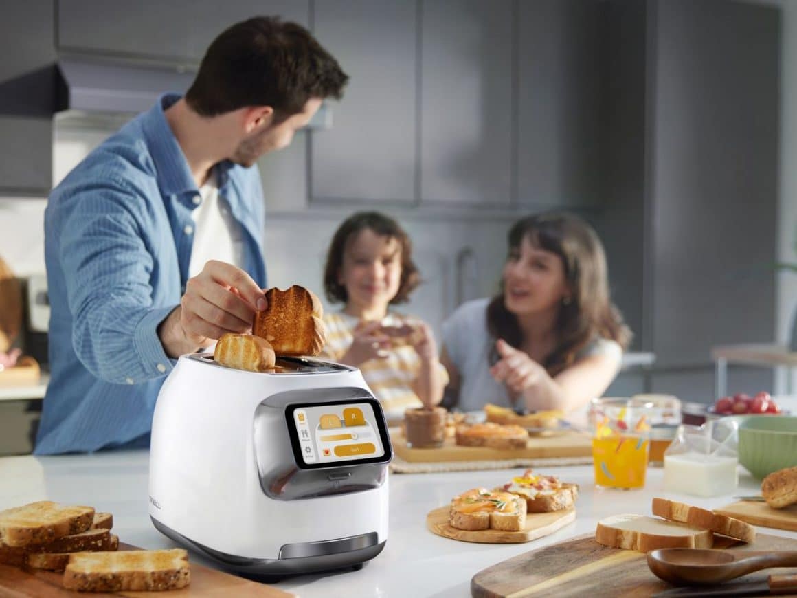 un barbat ia o felie de pâine prajită dintr-un toaster inteligent