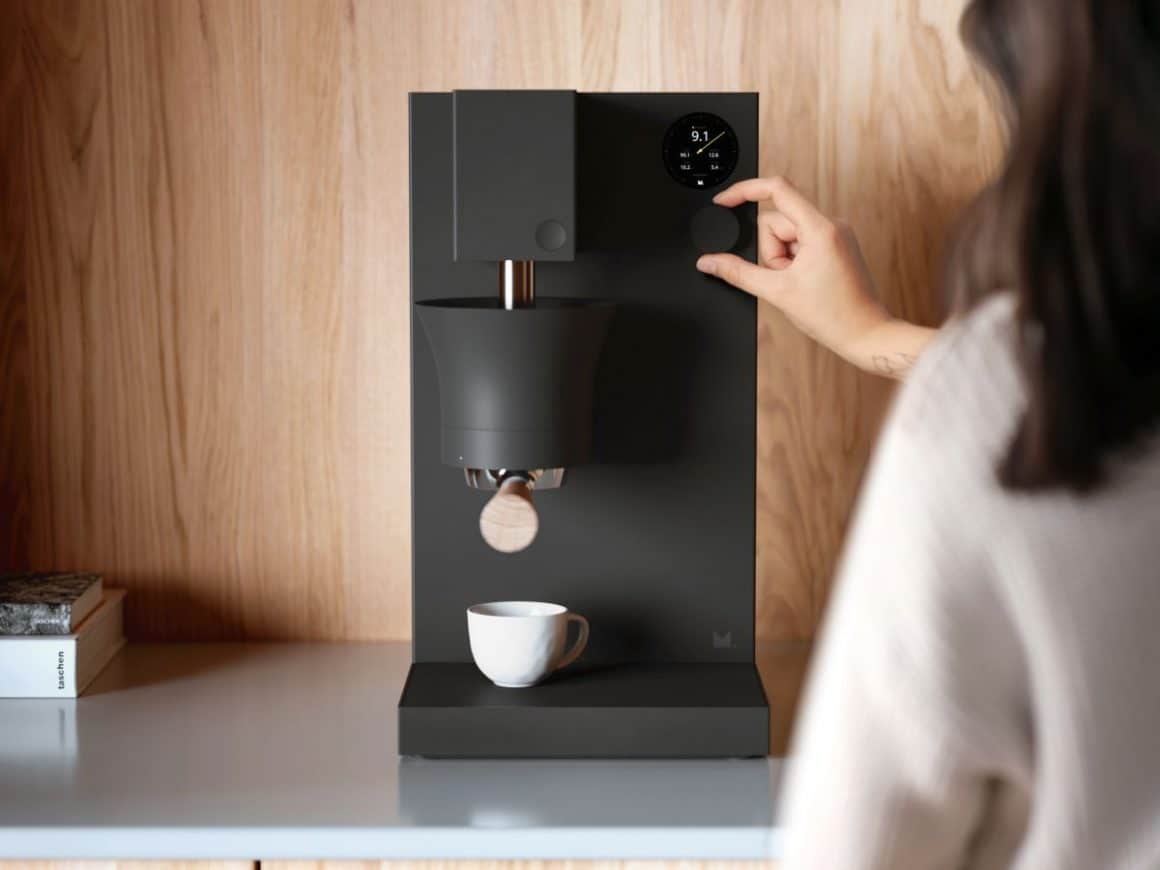 o mana de femeie programeaza un esspresor negru pentru un esspreso