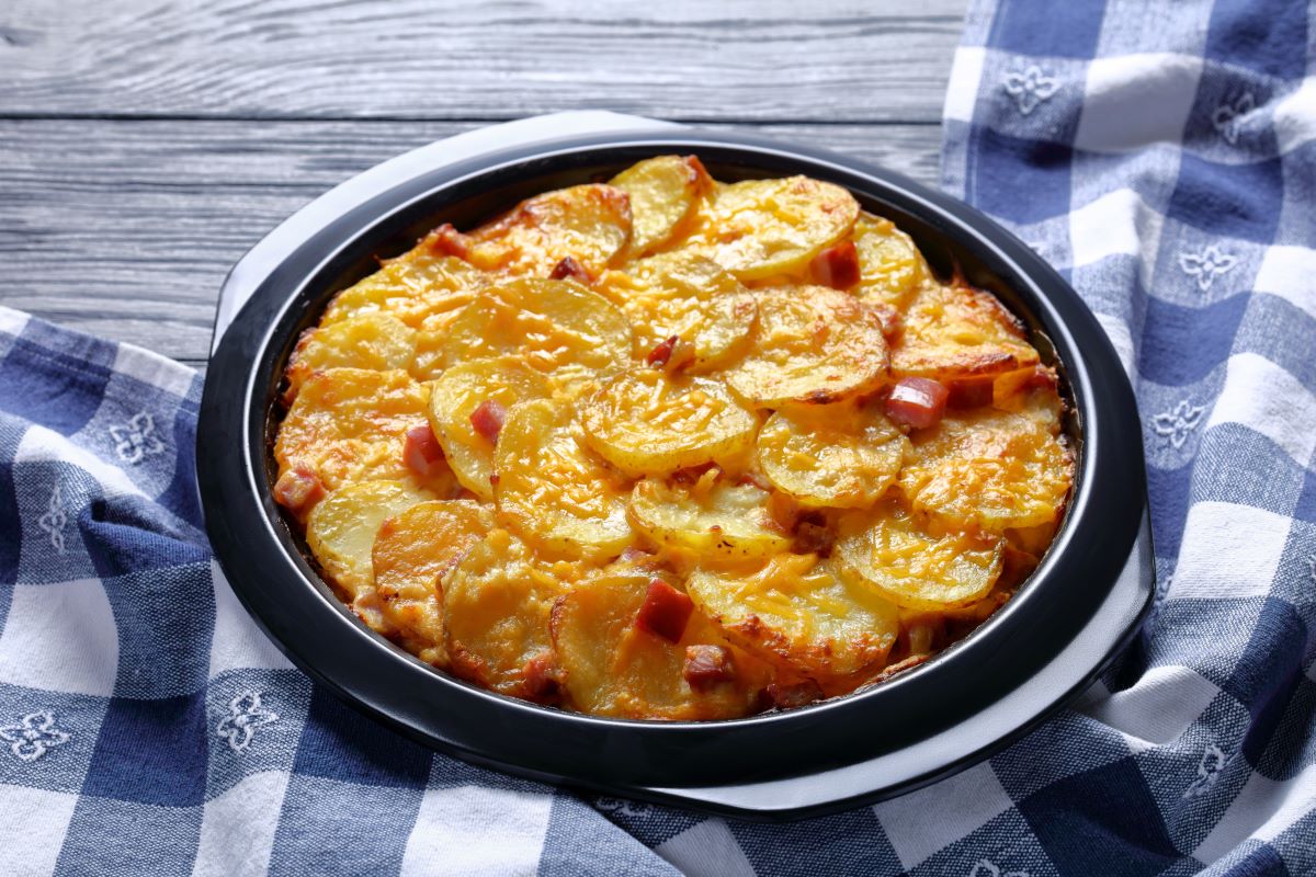 o tava neagra, circulară, cu cartofi au gratin