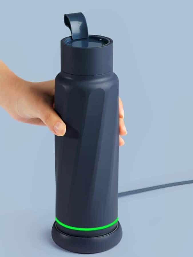 o sticla de apa inteligenta este pusa la incarcat de o mana de femeie